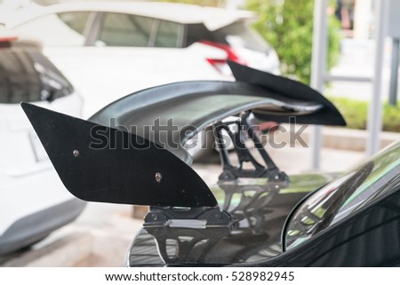 Car part ; Close up detail of a custom racing carbon fiber spoiler on the rear of a modern car with copy space
 Royalty-Free Stock Photo #528982945