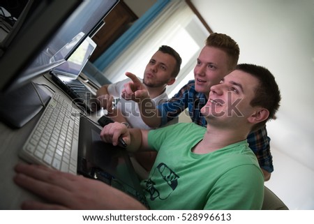 a group of young graphic designers working on a digital tablet and a computer