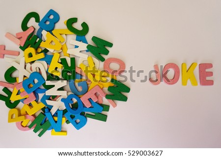 Word Joke made with block wooden colourful letters with a white background