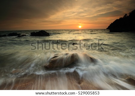 Beautiful blazing sunset landscape in the  sea and orange sky above it with awesome sun golden reflection on calm waves as a background. Amazing summer sunset view on the beach in Thailand