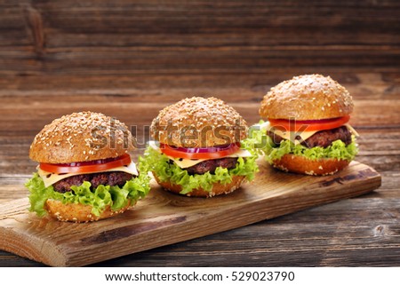 Hamburger with beef meat and fresh vegetables on wooden background
