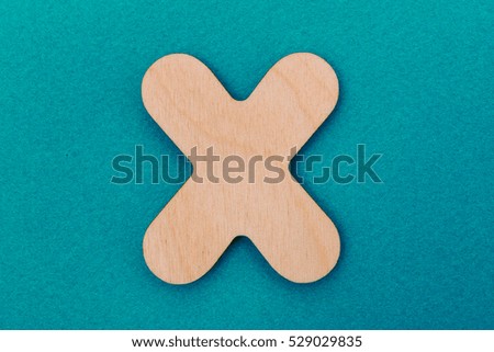 The letter of the English alphabet from yellow wood isolated on a blue background