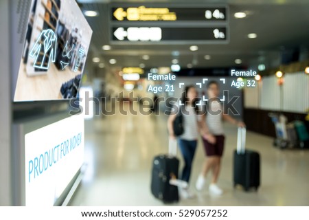 Intelligent Digital Signage marketing and face recognition concept. Two women walk through interactive artificial intelligence digital advertisement in retail shopping Mall.