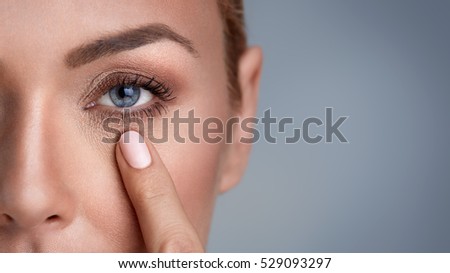
woman checking wrinkles around the eyes, close up  Royalty-Free Stock Photo #529093297