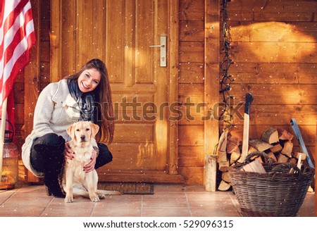 Smiling girl with sweet puppy in front of weekend house