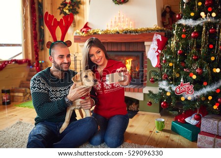 Photo of happy couple with dog at Christmas  
