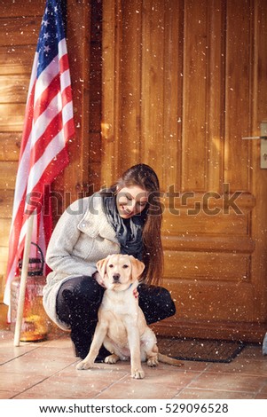 Smiling girl with sweet puppy in front of weekend house