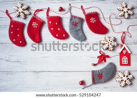 Christmas wooden background with red socks and gingerbread in the form of snowflakes