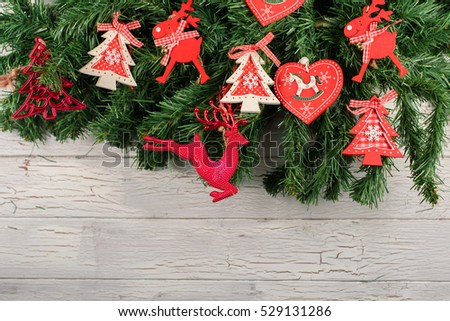 New Year decorations. Christmas tree with red hurts and funny deers on it. White wooden background