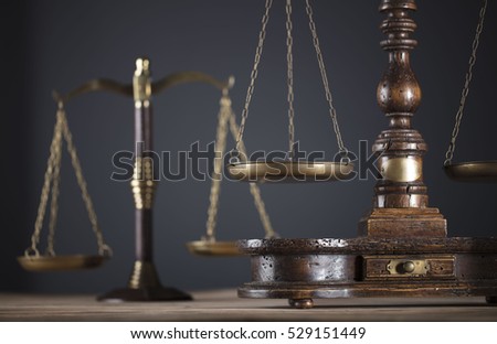 Law. Antique scales of justice on a wooden table. Gray background. Place for typography and logo.