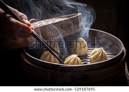 Boiled and hot chinese dumplings in wooden steamer Royalty-Free Stock Photo #529187695