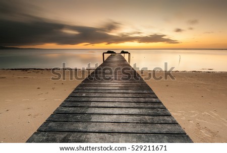 view of South China Sea from a wooden jetty during sunset. Image contain soft focus and blur due to long expose.