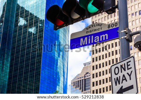 Milam street sign in downtown Houston, Texas with skyscrapers in the background.