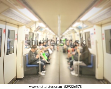 Blurred image of city people lifestyle is using smartphones inside the train , focus on the left door