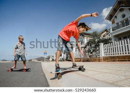 Little boys on longboard skate 