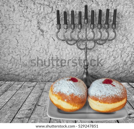 Menorah with candles and sweet donuts are traditional Jewish symbols for Hanukkah holiday. Selective focus. Image toned for inspiration of retro style and feast ceremony