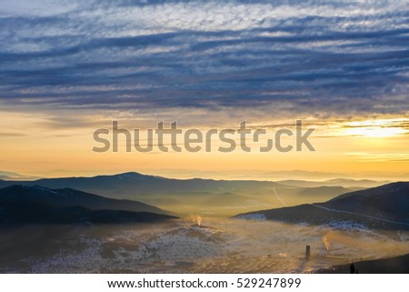 Sunset in the mountains landscape. Dramatic sky. Mountain forest landscape under evening sky in sunlight. cloudy sunrise in the mountains with snow ridge. Sheregesh. Small village in the mount