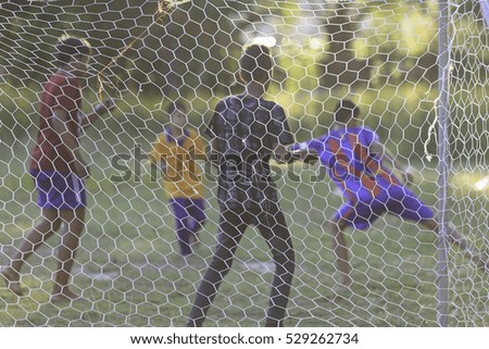 Blur picture of Young Asian boy play football in the park during summer.