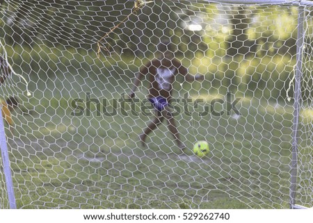 Blur picture of Young Asian boy play football in the park during summer.