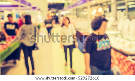 blurred image of people at shopping mall or exhibition hall for background usage . (vintage tone)