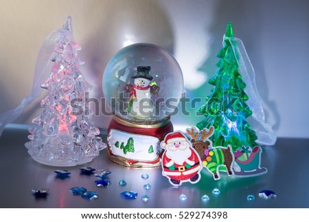 Santa Claus with Rudolf and sleigh with gifts, snowman, glowing trees and stars - Card
