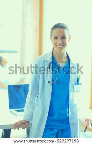 Woman doctor standing at hospital near desk