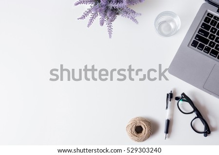 White office desk table with laptop, smartphone, pen, lavender, rope and glass. Top view with copy space, flat lay.