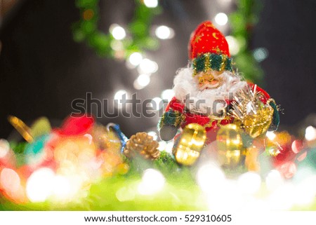 Santa claus doll in Christmas day on green grass and bokeh background. Morning sunshine day and good day.Happy time together in winter season.