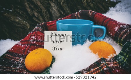 Cup of tea, red scarf and tangerines, words on paper happy new year