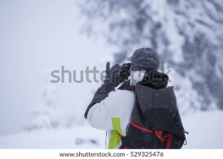 Man taking photos  in foggy winter landscape