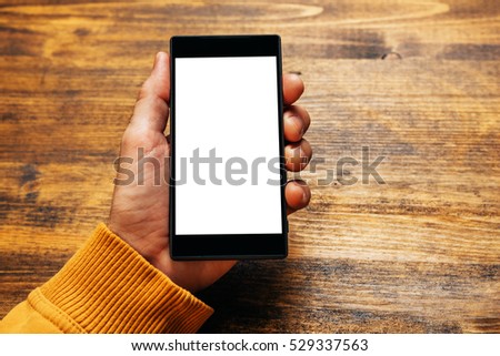 Mobile payment and electronics banking with smartphone, mock up image of male hand holding modern stylish device with blank screen as copy space