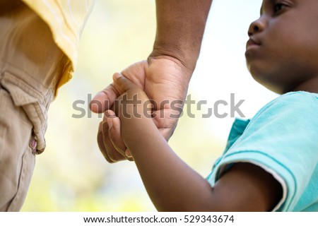 Father holding his sons hand. Royalty-Free Stock Photo #529343674