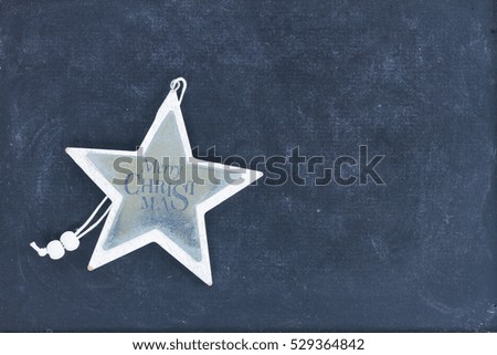 Merry Christmas star on black wooden background with copy space