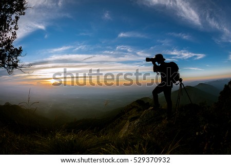 Silhouette of a landscape photographer in twilight