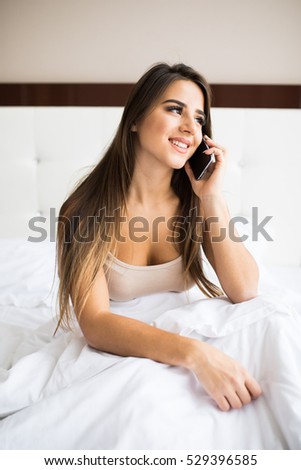 Beautiful girl speak phone in the bed