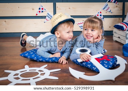 Little boy and girl having fun on photography in a nautical style.