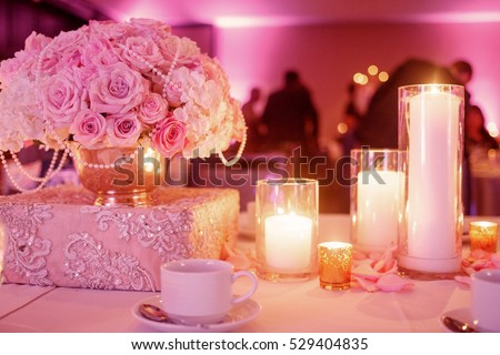 Lighted candles stand on the festive served dinner table