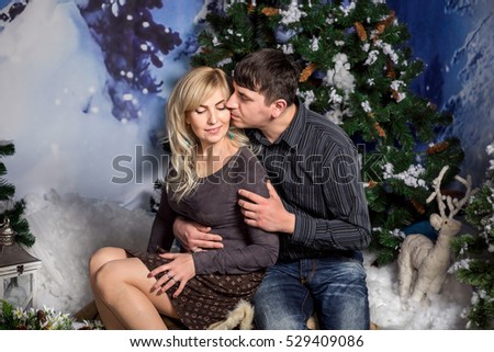 Winter couple kissing in winter decorations