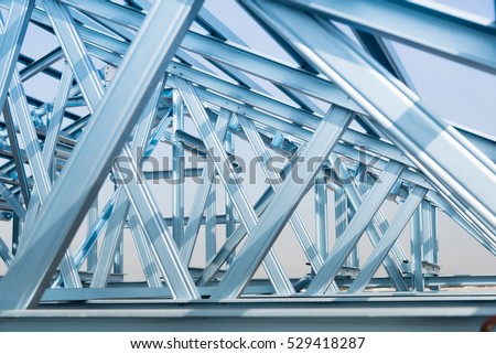 Structure of steel roof frame for building construction on sky background. Royalty-Free Stock Photo #529418287