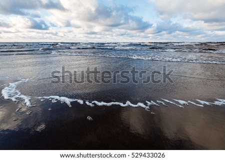 Stormy sea in winter with white waves crushing and seagulls
