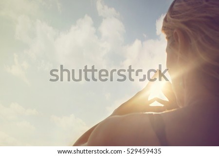 a new day begins with the sunrise protected in the hands of a woman Royalty-Free Stock Photo #529459435