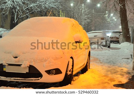 cars on a snowy night street