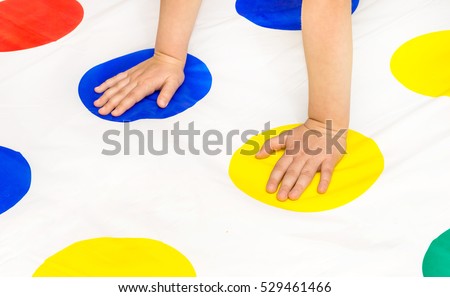 Child's hands on twister game Royalty-Free Stock Photo #529461466