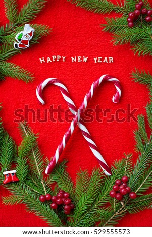 Christmas tree and candy on a red background with the words Happy New Year! Postcard