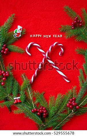 Christmas tree and candy on a red background with the words Happy New Year! Closeup