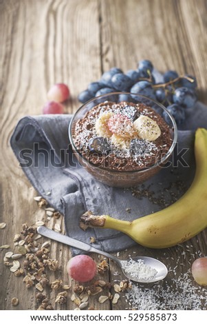 Chocolate chia pudding with fruit in the glass bowl vertical