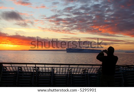 Cruise ship passengers taking pictures of sunset with tabular iceberg, 	Bransfield Strait,		Antarctica