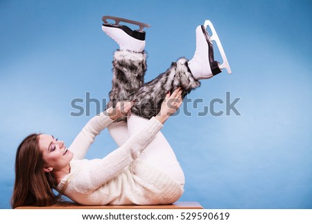 Woman wearing skates fur warm socks. Girl getting ready for ice skating. Winter sport activity. Studio shot on blue