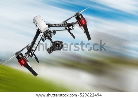 White drone quad copter with high resolution digital camera flying in the blue sky.