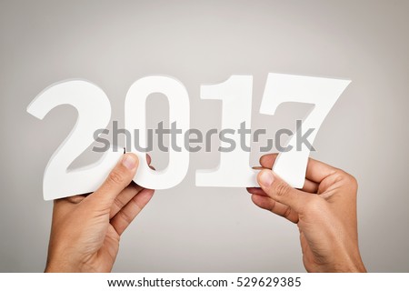young man holding some white numbers forming the number 2017, as the new year Royalty-Free Stock Photo #529629385